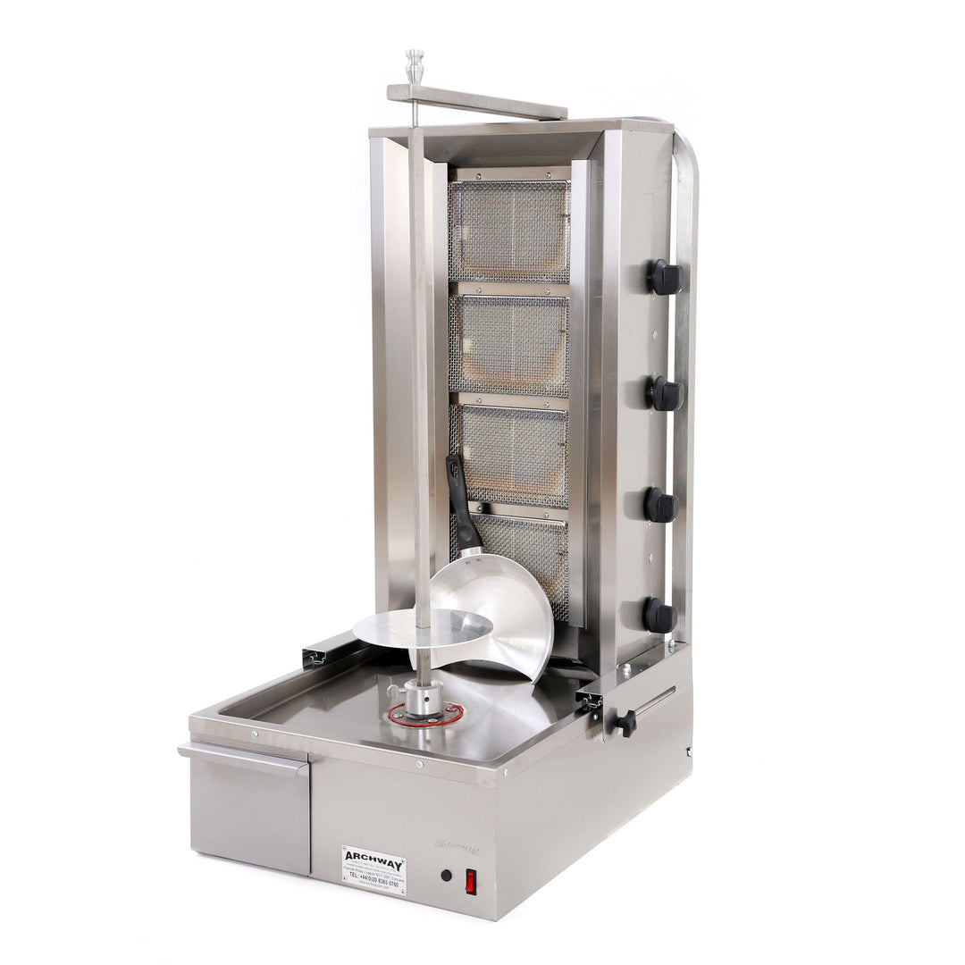 A commercial kebab grill machine with four burners, made of stainless steel, featuring a large round top with a central grilling area and a removable grease collection tray.