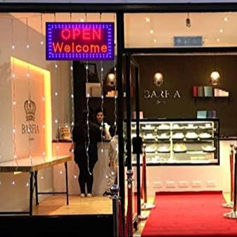 KRD bright flashing LED OPEN WELCOME sign displayed in shop window, measuring 48x25cm, multicolour light.