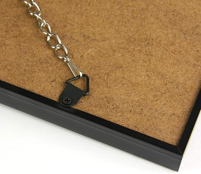 Close-up of a hanging chain and hook on the back of a picture frame, showing hanging mechanism and black frame edge.